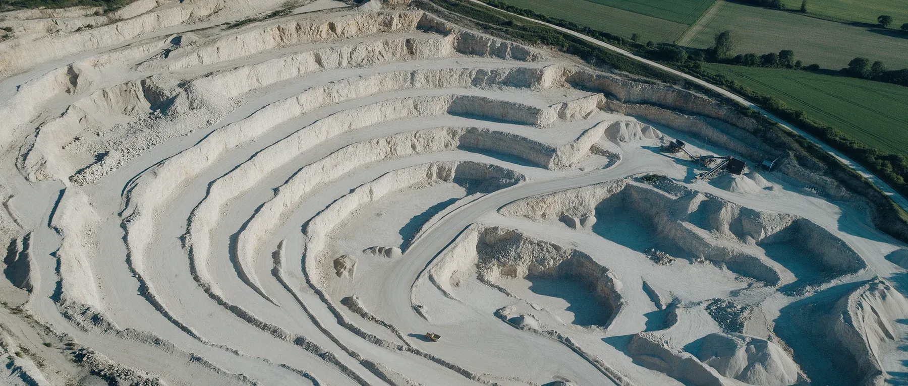 Illustrative aerial quarry landscape, generated with Seedream.